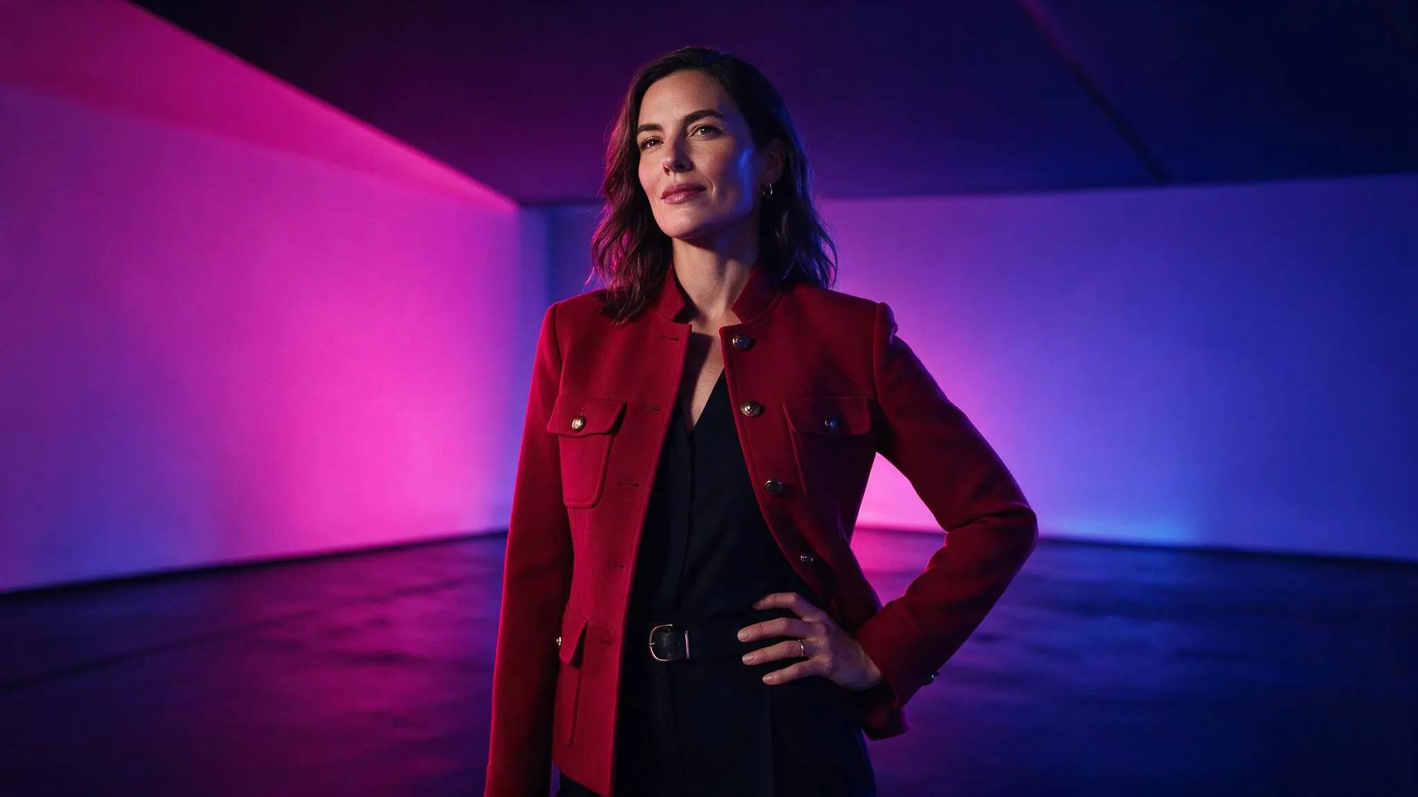 Fictional adult creator in a crimson-lit studio, shown as an illustrative AI video result